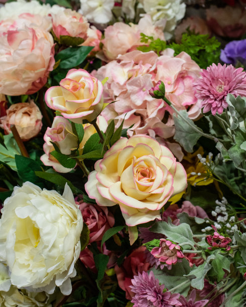 大朵人造茶玫瑰，粉黄细腻，家居装饰。可爱的手工玫瑰织物。垂直照片背景设计图片下载