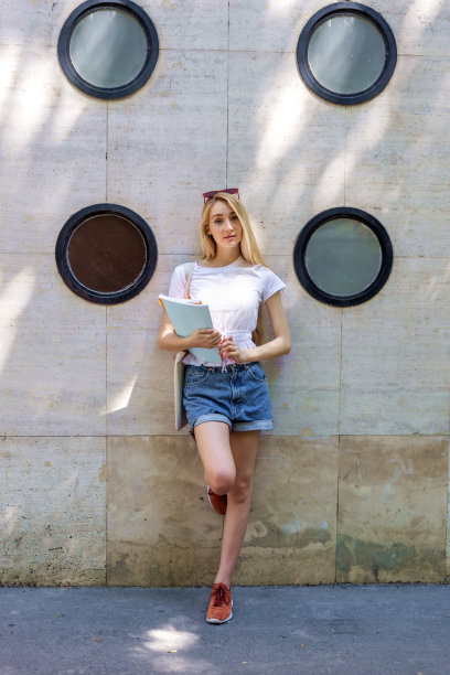 微笑的年轻女子站在街上等待某人图片下载