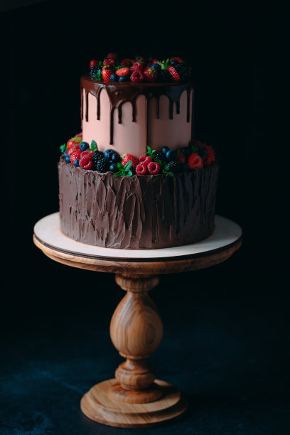 木架上的水果巧克力蛋糕以黑色为背景。图片下载