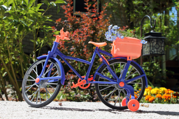 玩具自行车靠近一个花坛图片下载