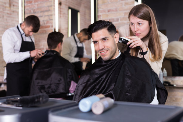 理发师用电动理发器为男士理发图片下载