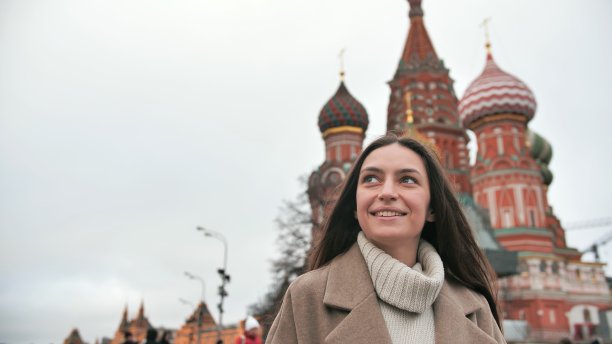 女孩游客走在俄罗斯的街道上欣赏周围的建筑。俄罗斯女性研究莫斯科风情图片下载