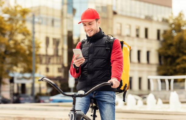 用户外应用程序把手机放在自行车上的快递员图片下载