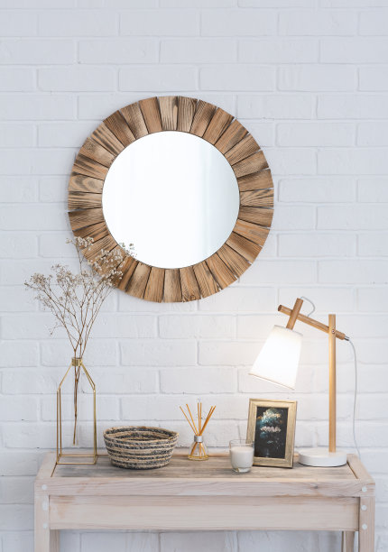 卧室内。花瓶里放着干花，木制梳妆台上放着香烛和灯，白砖墙上挂着圆镜图片下载