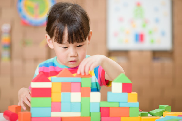 年轻女孩玩创造性玩具积木在家上学图片下载