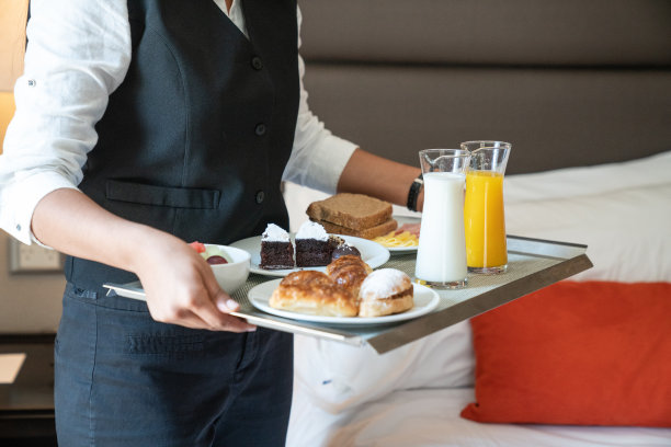 房间服务。一个年轻的拉丁女招待把早餐送到酒店房间的细节。图片下载