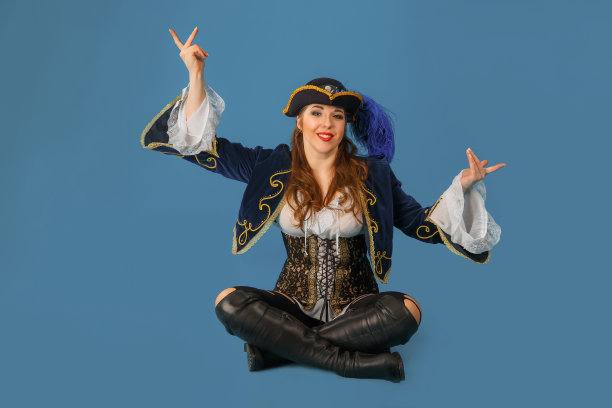 一个穿着狂欢节海盗服装戴着带羽毛帽子的女人的工作室肖像图片下载