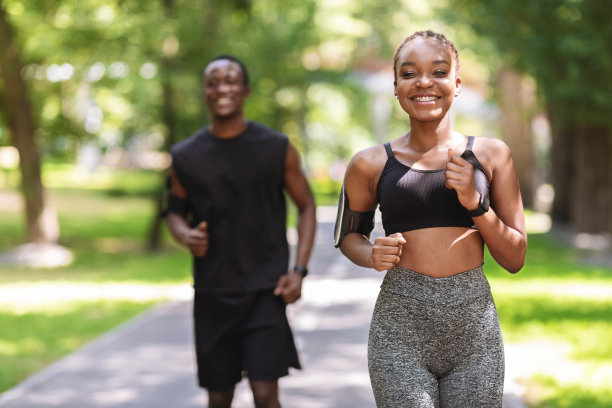 积极的生活方式的概念。非洲女孩和她的男性朋友在户外慢跑图片下载