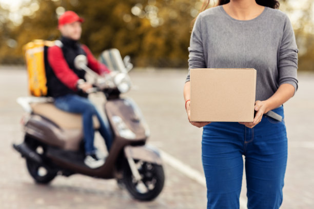 无法辨认的客户拿着盒子站在快递员旁边，裁剪图片下载