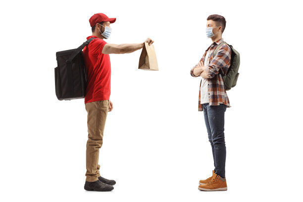 一名男子给一个戴着防护面罩的人送食物的全身像图片下载
