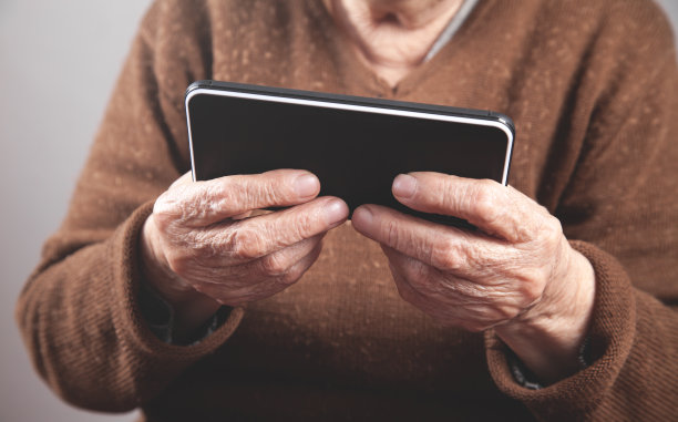 白人老年妇女使用智能手机。图片下载