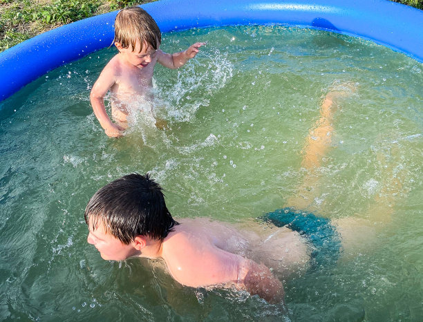 夏天，两个皮肤白皙的孩子在小屋的充气泳池里洗澡。图片下载