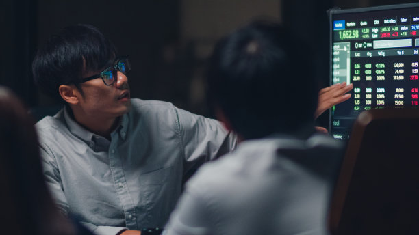 亚洲商务人士开会，头脑风暴的想法，进行业务演示，项目同事一起工作在小型现代化的夜间办公室。素材图片