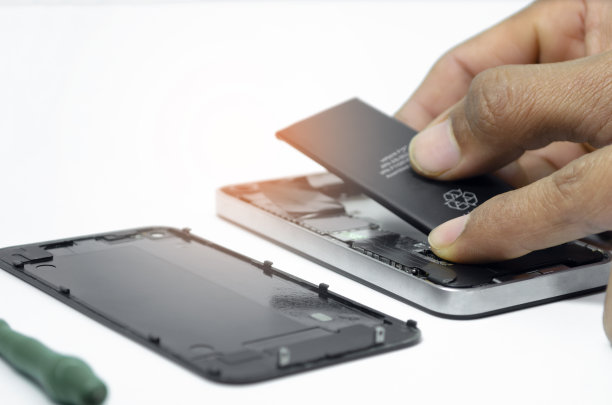 手机修理的特写安装电池到智能手机的主板由技术人员在工作室白色背景与迷你工具图片下载