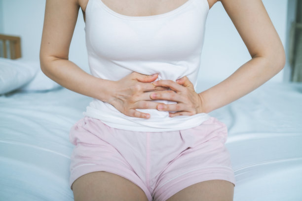 妇女在疼痛中触摸腹部图片下载