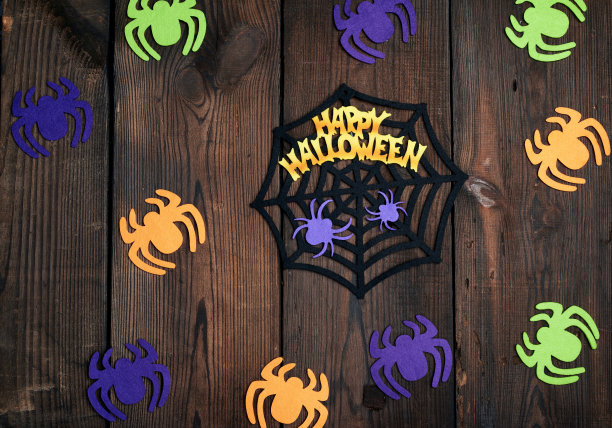 彩色毛毡蜘蛛图案，褐色木质背景上的蛛网图片下载