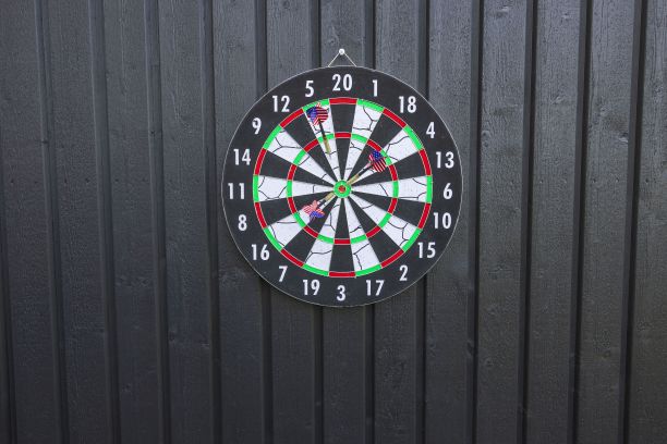 视飞镖板与导弹在黑色木墙孤立。运动和爱好的概念。图片下载