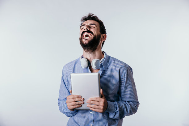 积极的年轻的蓄着胡子的自由职业者拿着一个平板电脑孤立的白色图片下载