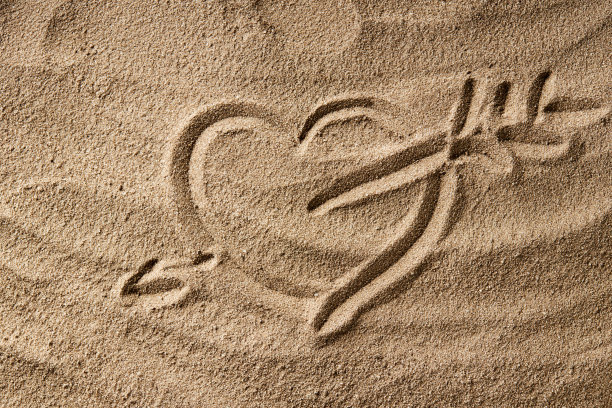 爱情和浪漫的概念。在沙滩上画心形符号。心理健康的概念。黑暗的喜怒无常图片下载