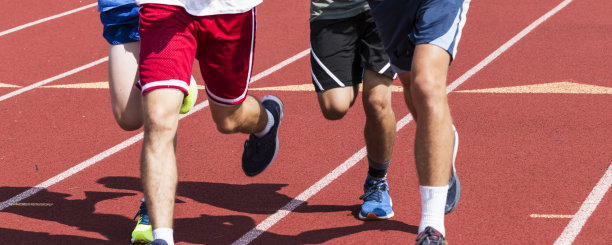 四个男孩的腿在跑道上奔跑图片下载
