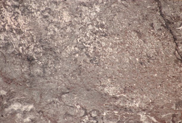 棕色天然石材的粗糙表面，带有裂缝和斑点特写图片下载