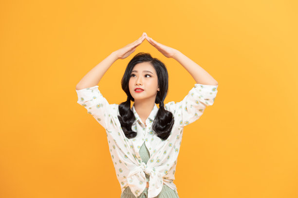 照片的好高兴的女人在雨衣做屋顶手势和微笑孤立在白色的背景图片下载