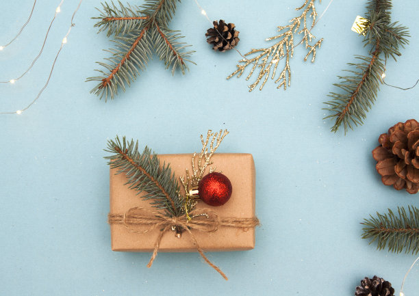 圣诞礼物装饰。概念照片圣诞礼物，新年准备。冷杉树和金色的树枝，装饰，花环在蓝色的背景。图片下载