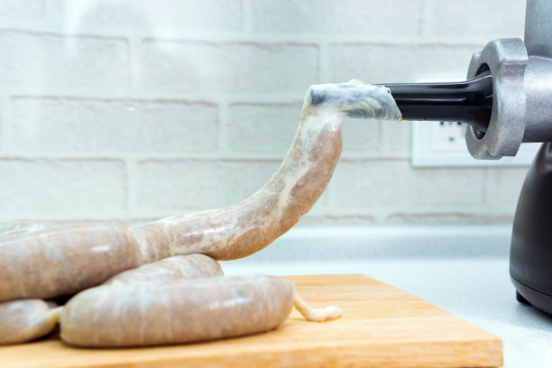 烹饪自制香肠的电动绞肉机。自制食物，选择性聚焦图片下载