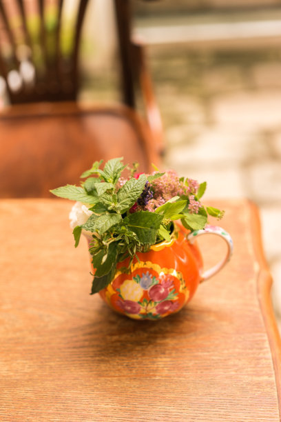 在漂亮的木桌上放着一个有铸币的旧陶罐。一个老咖啡馆的内部。图片下载