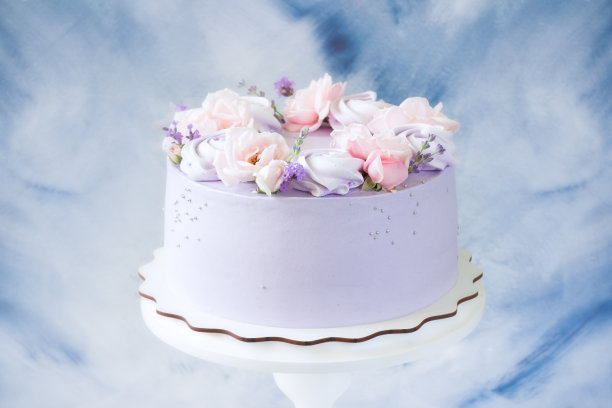 美丽的蛋糕。蛋糕上有粉红色的玫瑰花，紫色的蛋白酥皮放在木架上。婚礼蛋糕、生日蛋糕、母亲节、3月8日、妇女节、玫瑰和薰衣草蛋糕图片下载