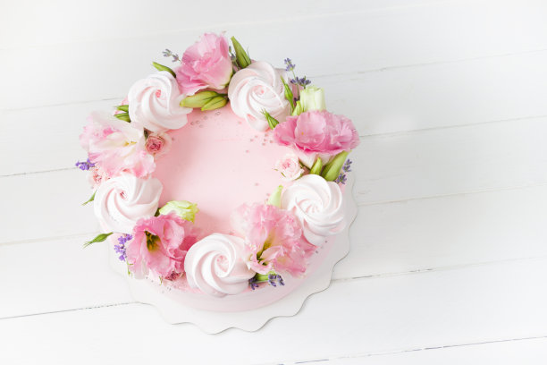 粉色的蛋糕。蛋糕上面有蛋白霜和粉红色的花朵。婚礼概念，圣瓦伦丁节，母亲节，生日蛋糕。漂亮的蛋糕在白色木板上图片下载