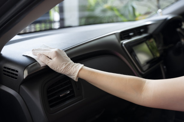 女人的手正在用湿巾擦拭控制台的表面。图片下载