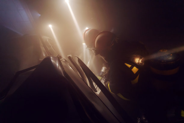 勇敢的消防队员把人从燃烧的汽车中解救出来。图片下载