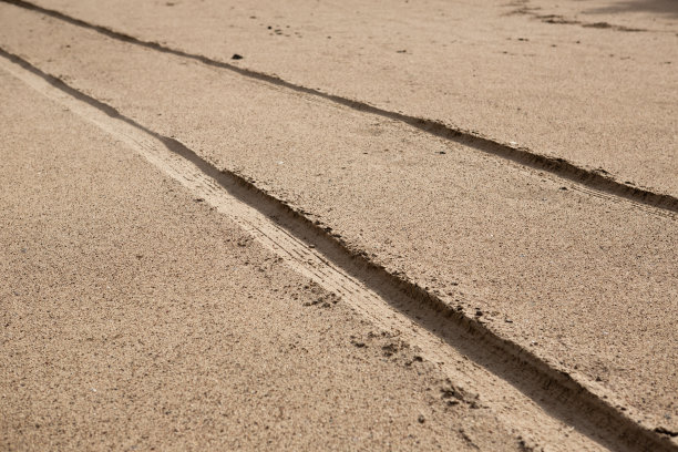 从沙滩上可以看到汽车轮胎的痕迹。图片下载