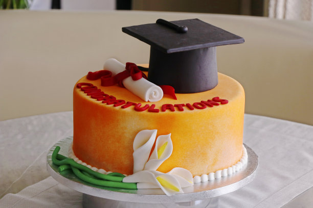 绿色草地背景下的毕业蛋糕图片下载