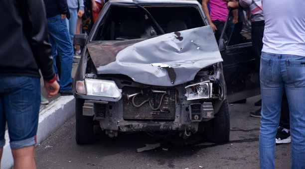 模糊图像的一辆汽车在事故中坠毁。一群人在一辆撞毁的汽车旁。软焦点图片下载