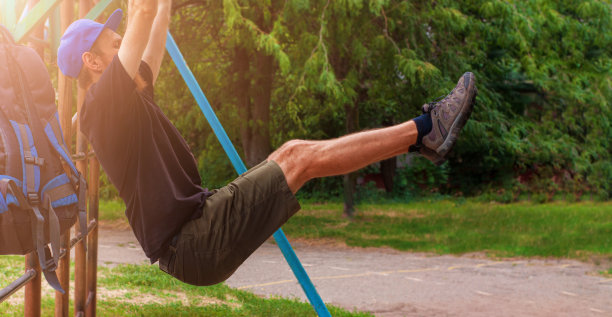运动员在单杠上做引体向上。男运动员在工作间隙到户外运动场上健身。图片下载