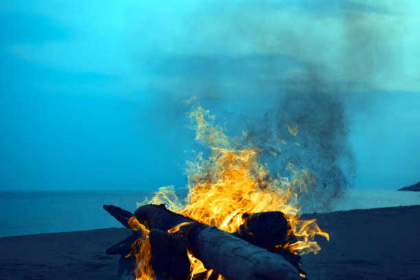 海滩上发生了一场大火。晚上的时间。明亮的火焰。毁灭性的火灾。晚上的风景。图片下载