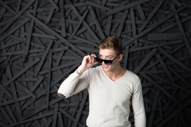 男人戴上眼镜微笑。看了。暗的背景图片下载