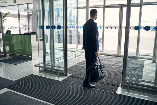 一个带着行李离开机场的年轻人图片下载