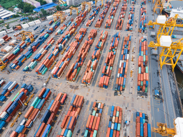 日落时分，无人机吊车桥在船厂拍摄，物流进出口和运输行业背景图片下载