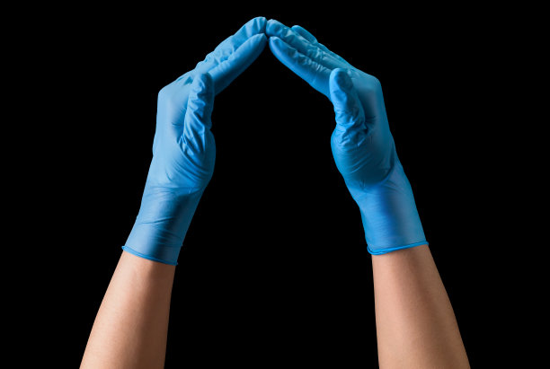 医生的手在无菌医疗手套显示心形孤立在黑色图片下载