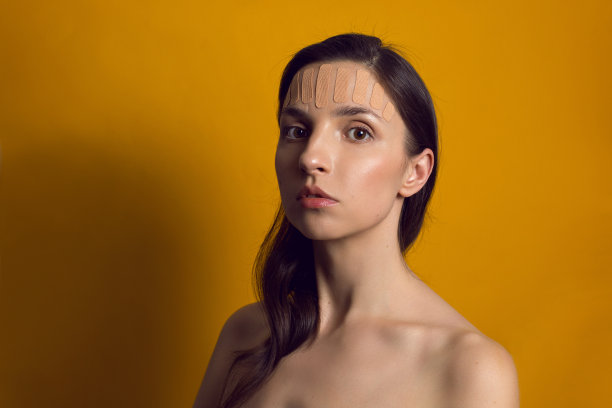 一个脸上贴着棕色运动机能学胶带的年轻女孩图片下载