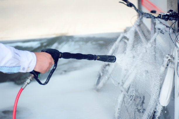 那家伙用泡沫清洗自行车。图片下载