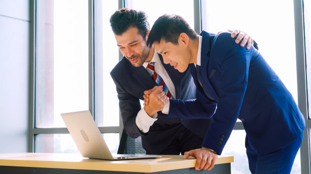 两个快乐的商业人士在办公室庆祝图片下载