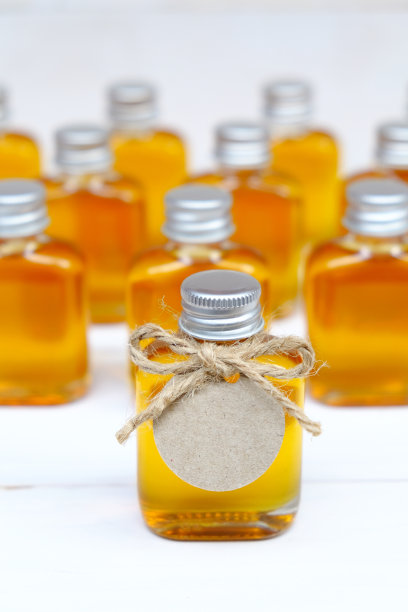 蜂蜜装在玻璃瓶里，作为结婚礼物，上面有棕色的标签。给客人的结婚礼物。婚礼讲究概念。图片下载