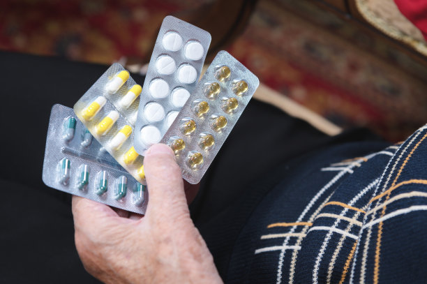 一个老妇人手里拿着不同的药片。老年人药物选择问题的概念及其成本图片下载