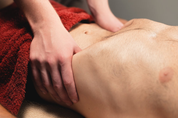 一名物理治疗师按摩师为一名肌肉强健的男运动员客户进行膈肌按摩。特写镜头。景深小图片下载