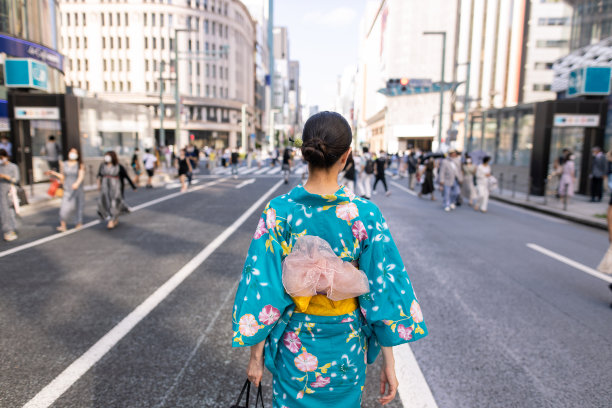 年轻女子在yukata走在街上的后视图，在周末禁止车辆通行图片下载