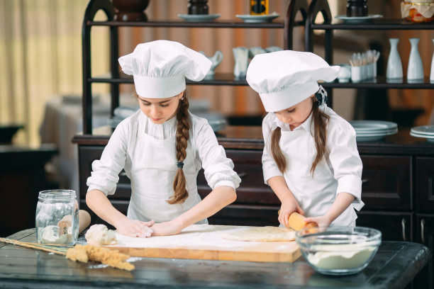 有趣的女孩，孩子们正在厨房里准备生面团。图片下载